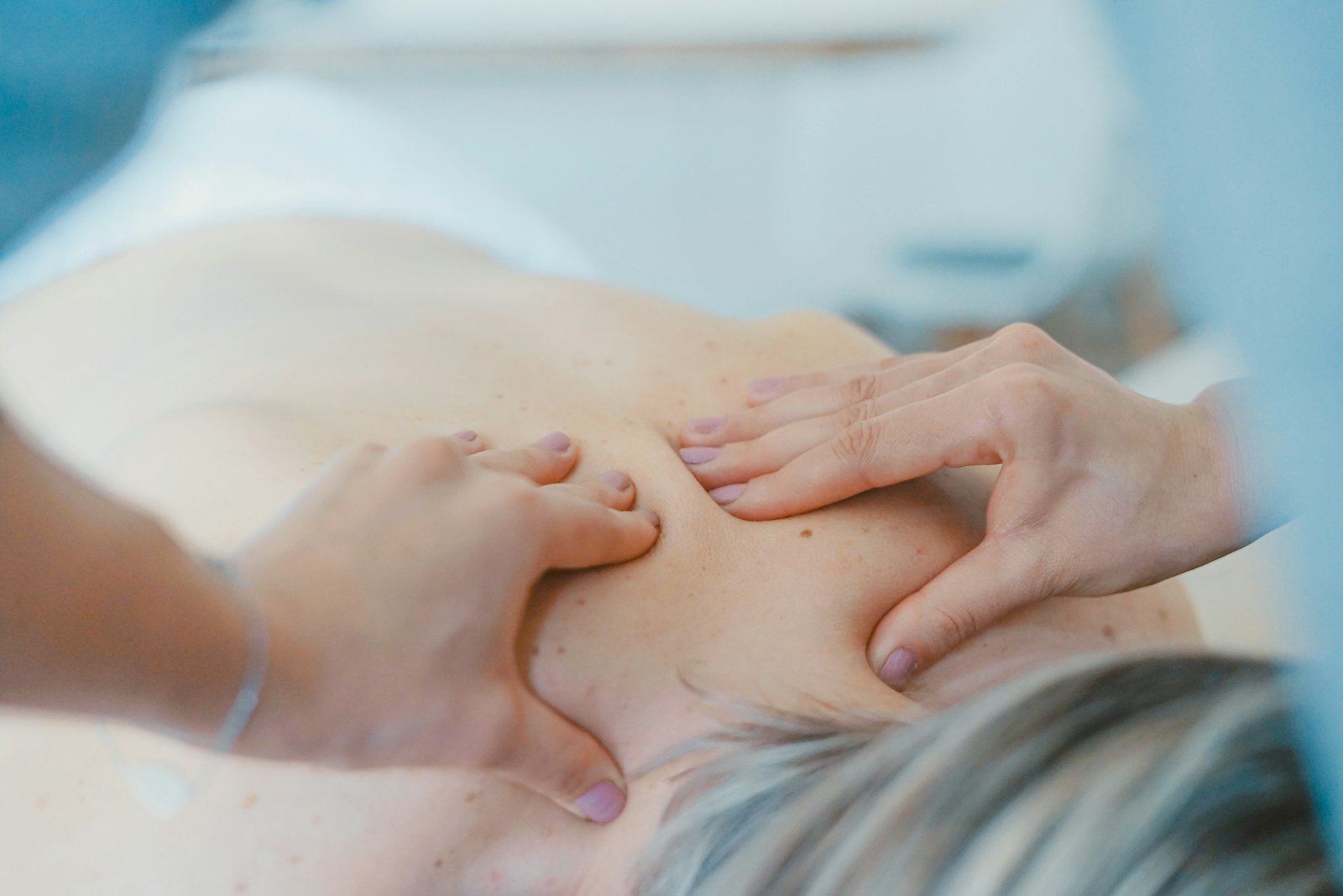 Osteopatia Częstochowa — dłonie terapeuty na górnej części pleców